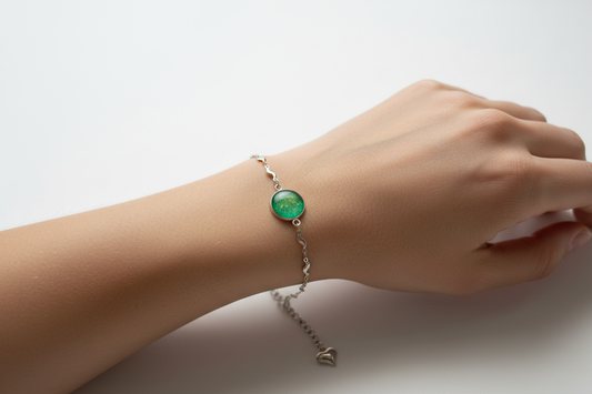 Pulseira verde com brilhos dourados num pulso